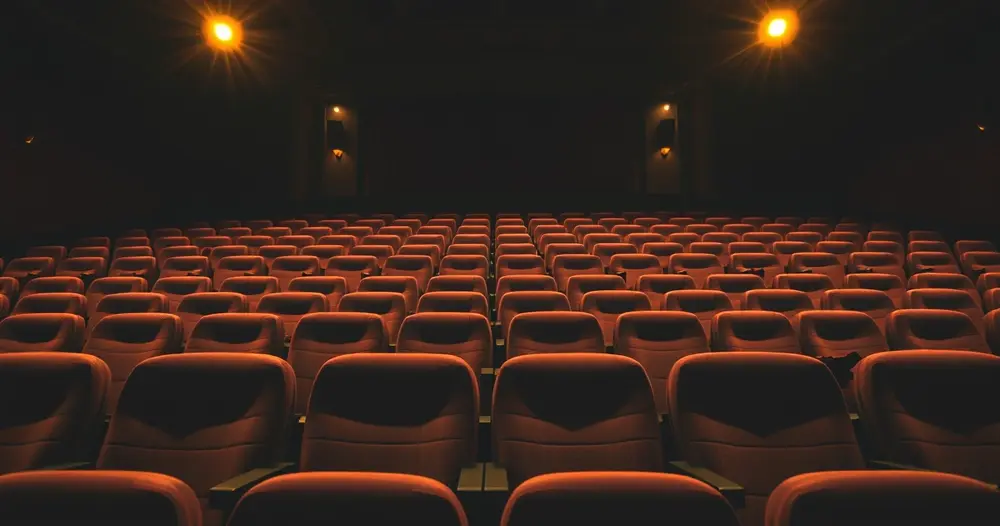 poltronas de cinema antigo em sala vazia com luz baixa